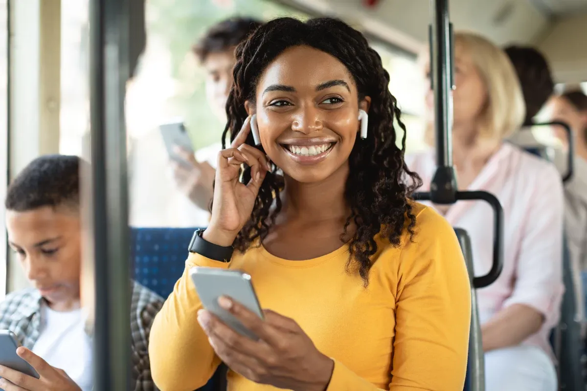 Persona con audífonos Bluetooth en el transporte público