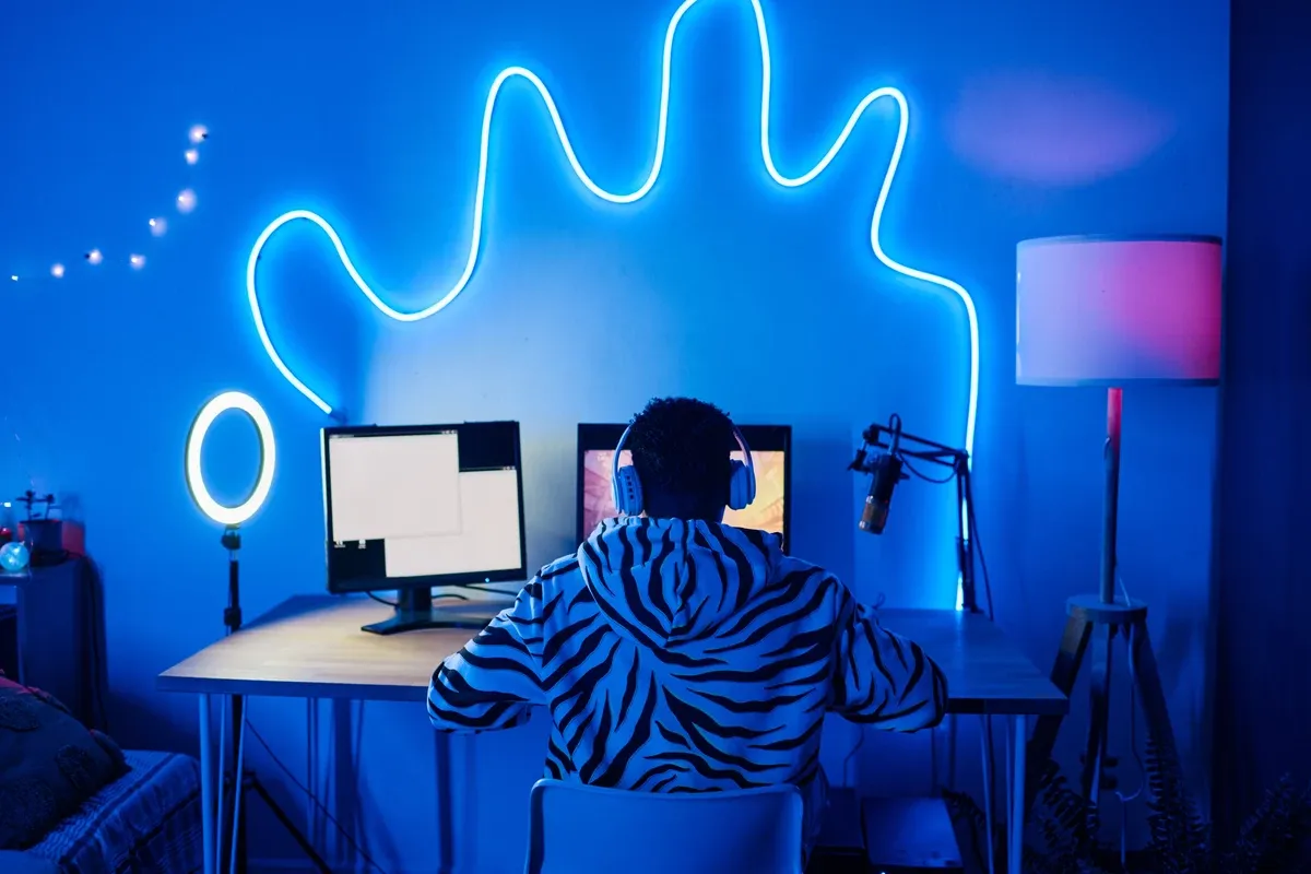 Streamer transmitiendo con micr&oacute;fono en una sala con luces ne&oacute;n