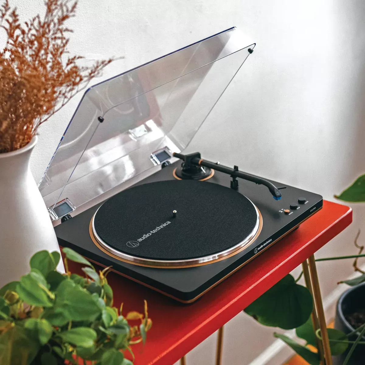 Tornamesa Audio-Technica AT-LP70X en negro y bronce sobre una mesa del living