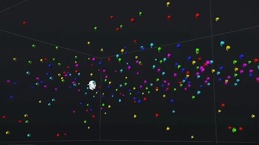 Vista 3D de Spacelab Interstellar mostrando cientos de esferas de colores repartidas por toda la sala virtual alrededor de una pequeña cabeza blanca que representa al oyente en el centro