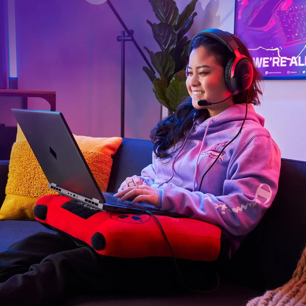 Jugadora con los HyperX Cloud III negro y rojo puestos frente a su notebook