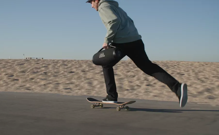 Persona en patineta con el JBL Boombox 3 Wi-Fi en la costanera