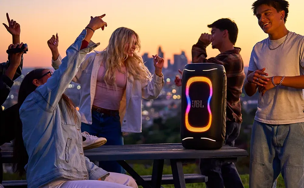 Grupo de amigos bailando al atardecer junto al JBL PartyBox 130