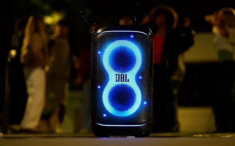 JBL PartyBox 520 con luces azules en una fiesta de noche