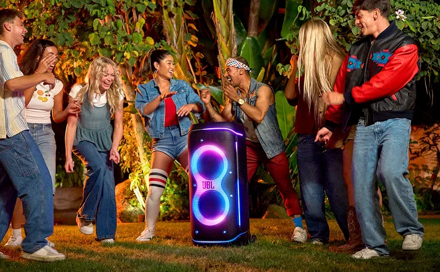 Fiesta en un jardín de noche con el JBL PartyBox 720 iluminado