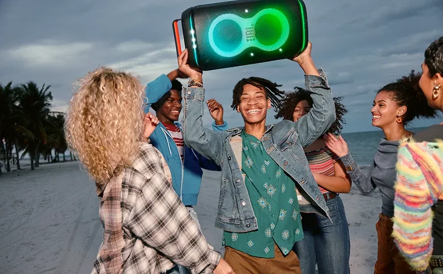 Gente bailando en la playa con el JBL PartyBox Club 120