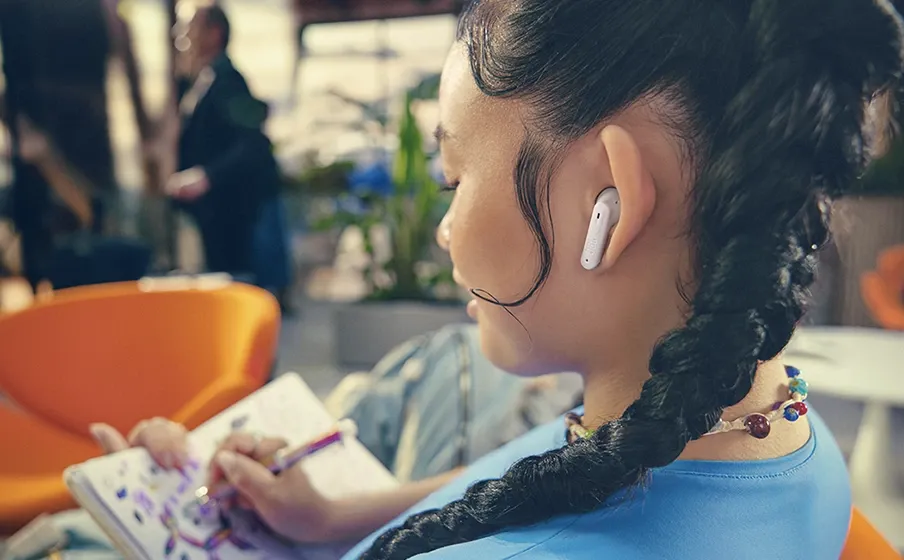 Mujer dibujando con los JBL Tune Flex 2 blancos puestos