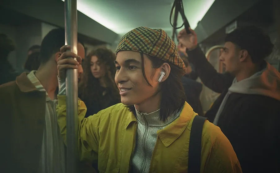 Hombre hablando en el metro con los JBL Tune Flex 2 blancos puestos