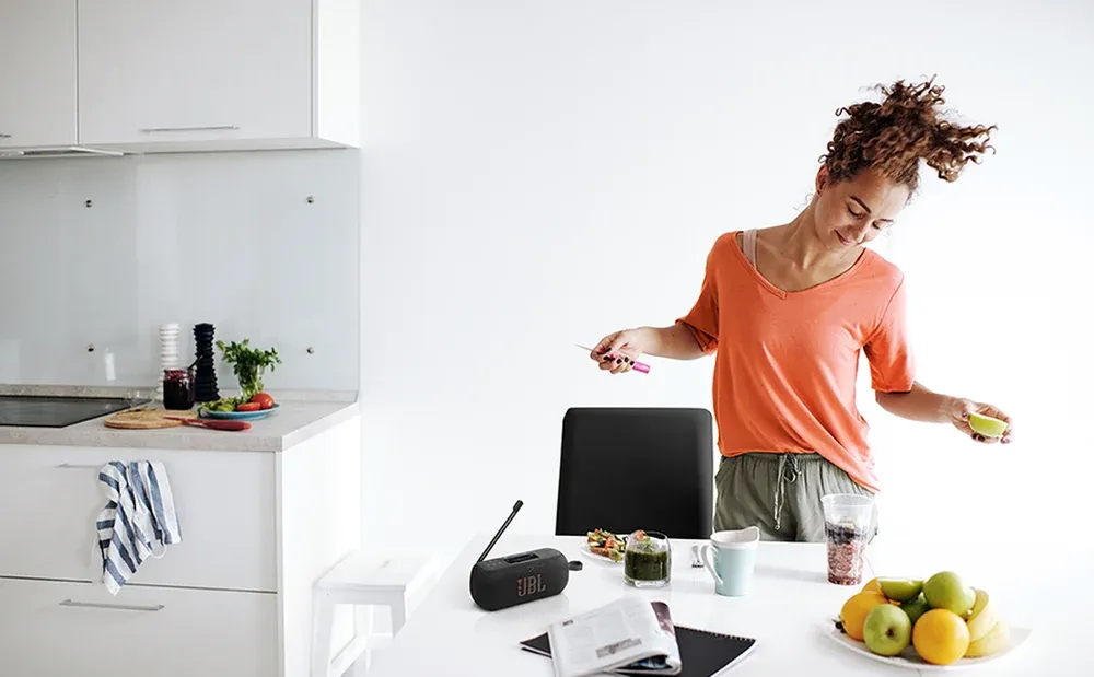 JBL Tuner 3 sobre la encimera de una cocina mientras alguien cocina