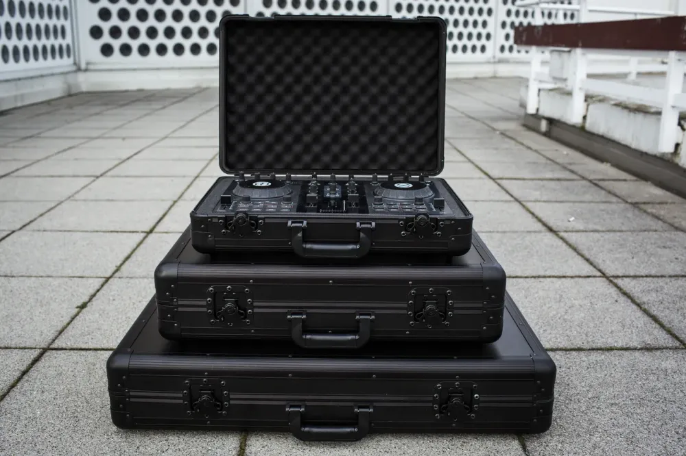Tres tamaños de Magma Carry Lite DJ-Case apilados, el superior abierto con un controlador DJ protegido