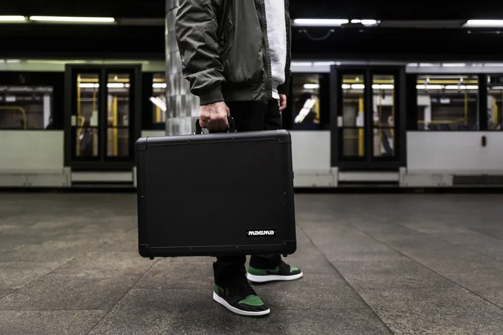 DJ llevando un maletín Magma Carry Lite DJ-Case por el andén del metro