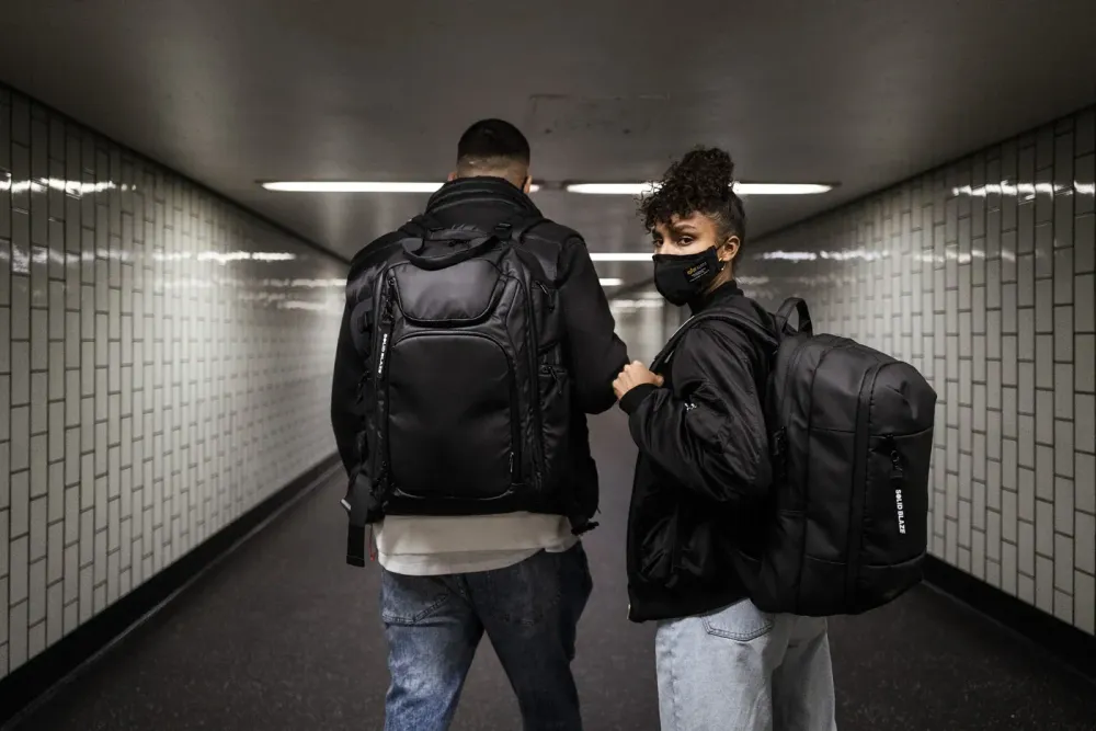 Dos DJs en un pasillo de metro con mochilas Magma Solid Blaze Pack de distinto tamaño