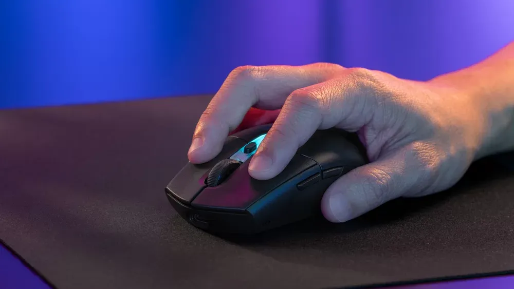 Mano usando el Logitech G305 X SUPERLIGHT negro sobre un mouse pad