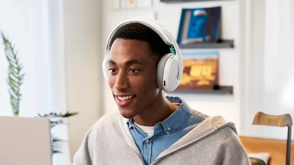Persona hablando con el Logitech G325 blanco y su micrófono beamforming integrado