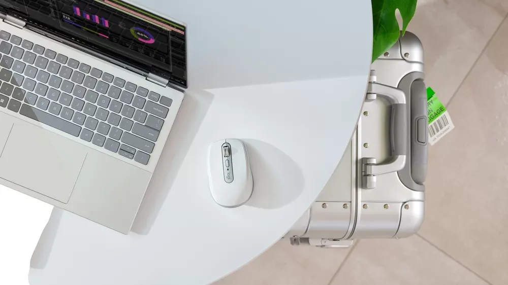 Logitech MX Anywhere 3S junto a un notebook en el escritorio