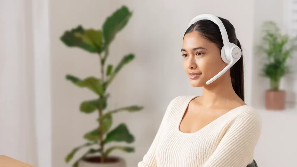 Mujer en una videollamada desde su casa con los Logitech Zone 300 blancos
