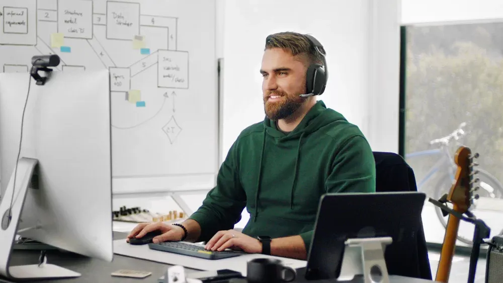 Hombre en una videollamada con los Logitech Zone Vibe 100