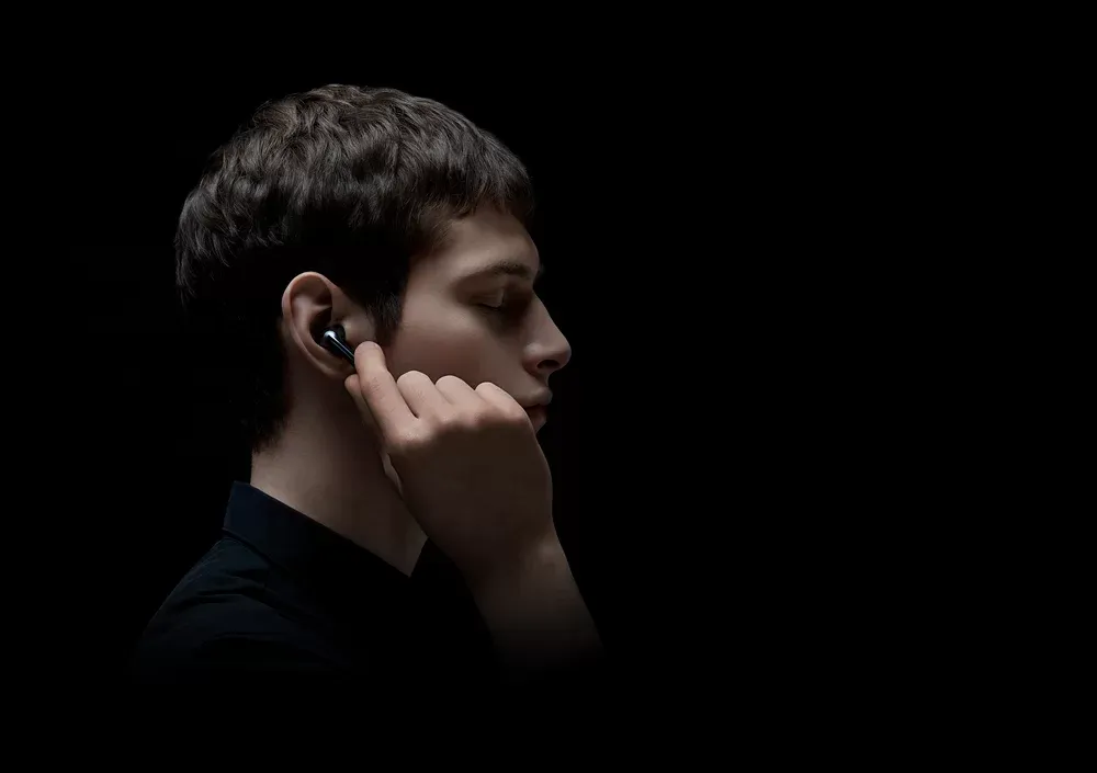 Hombre tocando el costado de un Xiaomi FlipBuds Pro para controlarlo