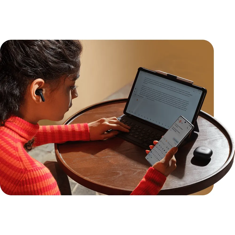 Mujer trabajando en su notebook y su celular con los Redmi Buds 8 Lite negros puestos