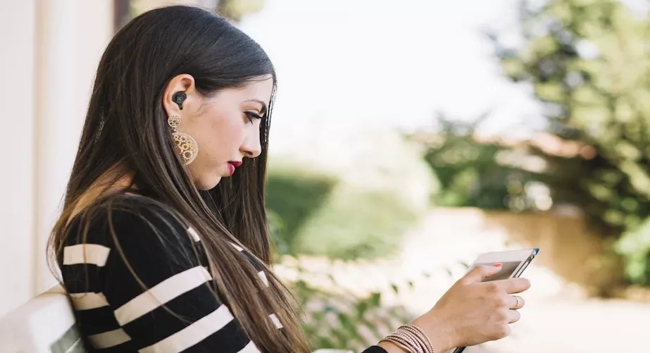 Mujer usando los Xtech Xound XTH-701 con su teléfono